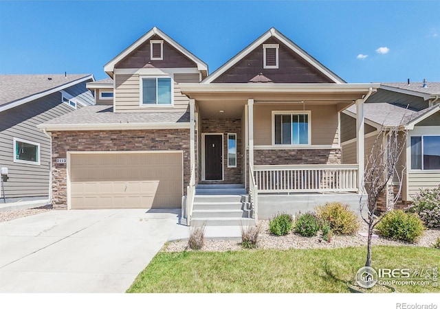 2113 Day Spring Dr, Windsor, CO 80550 - view of front of home with covered porch, driveway, stone siding, a garage, and a shingled roof