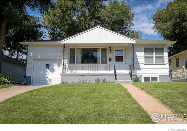 2211 10th Ave, Greeley, CO 80631 - view of front of house featuring a garage, a porch, driveway, and a front lawn