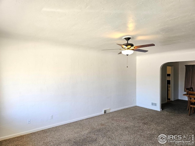 2211 10th Ave, Greeley, CO 80631 - empty room with arched walkways, a textured ceiling, a ceiling fan, visible vents, and carpet floors