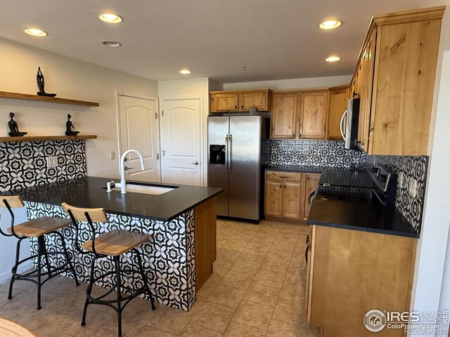 585 Callisto Dr, Loveland, CO 80537 - kitchen featuring open shelves, a sink, dark countertops, a peninsula, and stainless steel appliances