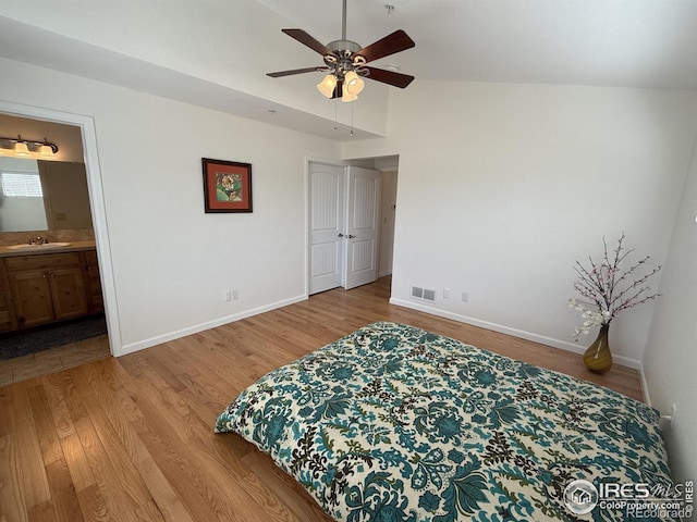 585 Callisto Dr, Loveland, CO 80537 - bedroom with visible vents, baseboards, a sink, vaulted ceiling, and light wood-style flooring