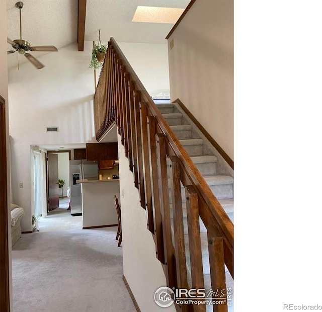 6239 Willow Ln, Boulder, CO 80301 - staircase with visible vents, beamed ceiling, a skylight, a ceiling fan, and a high ceiling