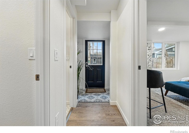 234 Lyons St, Fort Collins, CO 80521 - doorway with wood finished floors, a textured wall, and baseboards