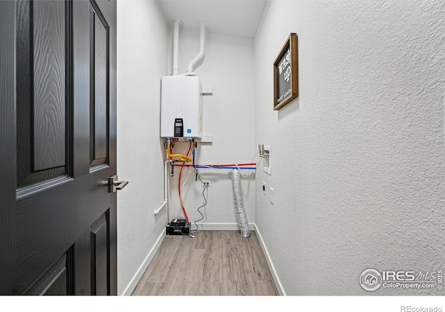 234 Lyons St, Fort Collins, CO 80521 - washroom featuring laundry area, water heater, wood finished floors, a textured wall, and baseboards