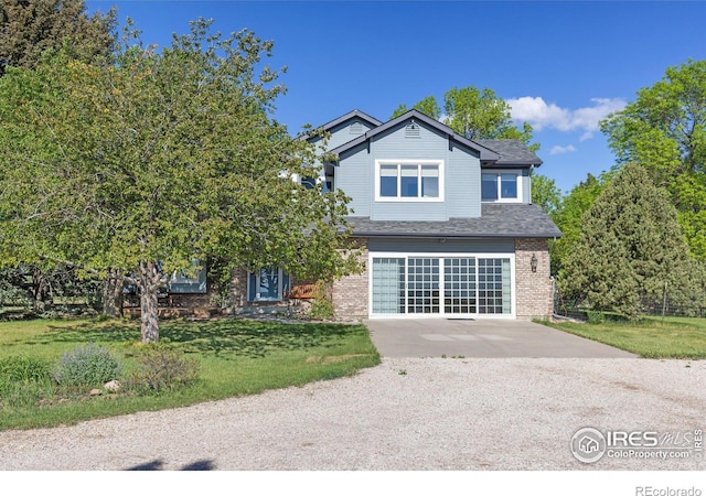 2610 W County Road 4, Berthoud, CO 80513 - view of front of house with driveway, brick siding, an attached garage, a front lawn, and a shingled roof
