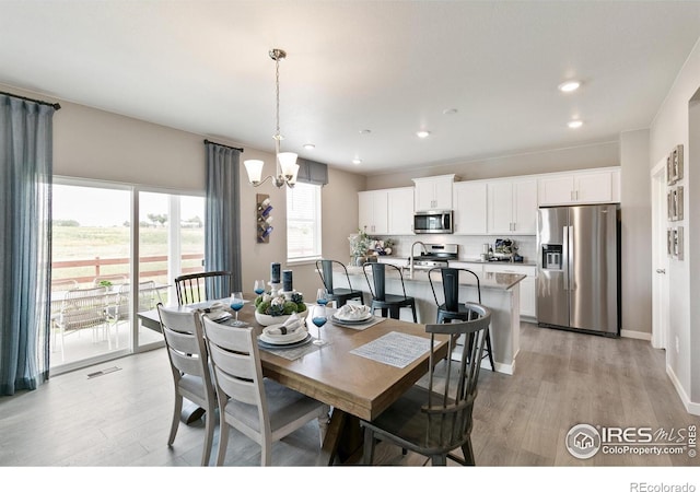 dining room featuring baseboards, a chandelier, recessed lighting, light wood-style floors, and visible vents