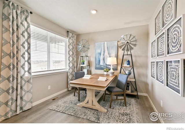home office featuring wood finished floors, baseboards, and visible vents