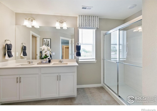 bathroom featuring a sink, visible vents, double vanity, and a stall shower