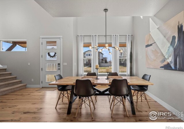 381 Pilsner St, Fort Collins, CO 80524 - dining space featuring wood finished floors, a notable chandelier, baseboards, and stairs