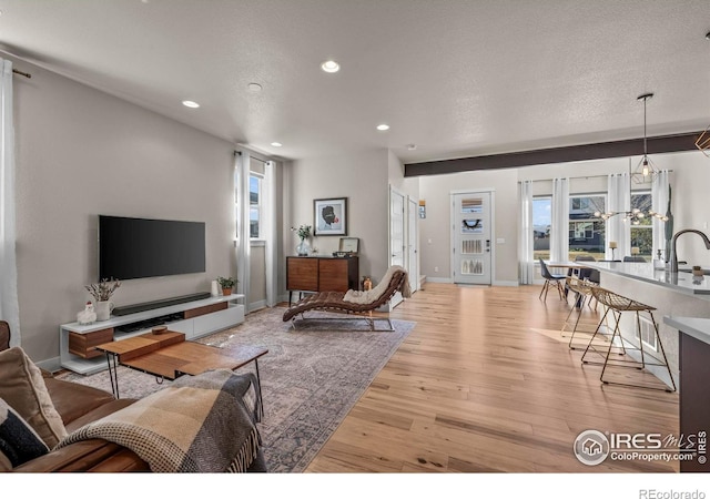 381 Pilsner St, Fort Collins, CO 80524 - living room featuring baseboards, recessed lighting, light wood-style floors, and a textured ceiling