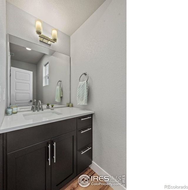 381 Pilsner St, Fort Collins, CO 80524 - bathroom with baseboards, a textured wall, a textured ceiling, vanity, and wood finished floors