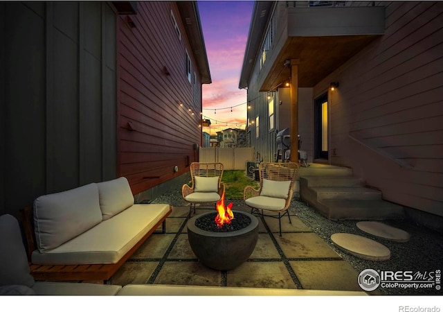 381 Pilsner St, Fort Collins, CO 80524 - patio terrace at dusk with an outdoor living space with a fire pit and fence