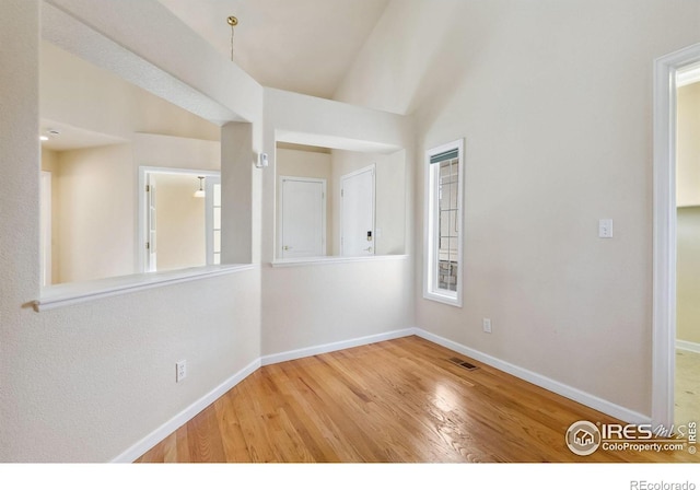 7747 Promontory Dr, Windsor, CO 80528 - spare room with baseboards, wood finished floors, and lofted ceiling