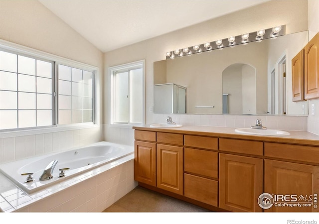 7747 Promontory Dr, Windsor, CO 80528 - bathroom with a whirlpool tub, double vanity, and lofted ceiling