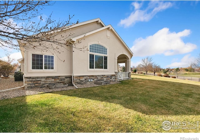 7747 Promontory Dr, Windsor, CO 80528 - view of property exterior with stucco siding, a yard, and central AC unit