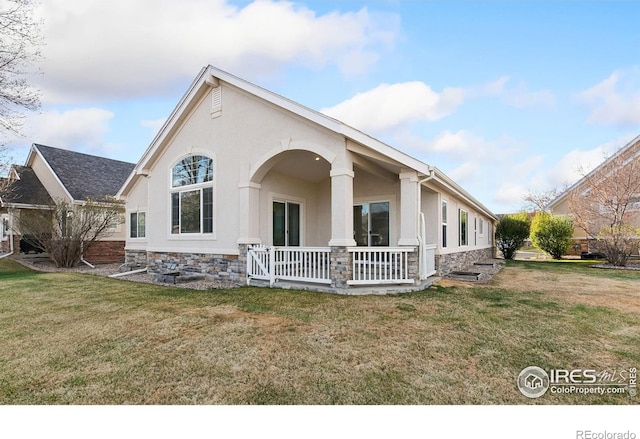 7747 Promontory Dr, Windsor, CO 80528 - rear view of property with a porch, stone siding, a yard, and stucco siding