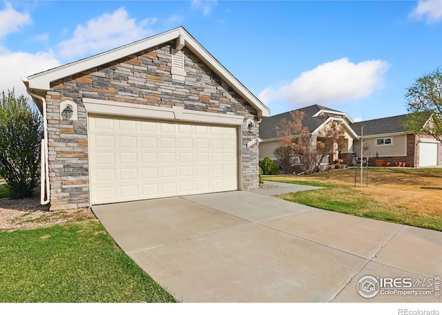 7747 Promontory Dr, Windsor, CO 80528 - view of front of home featuring a front yard, stone siding, and concrete driveway