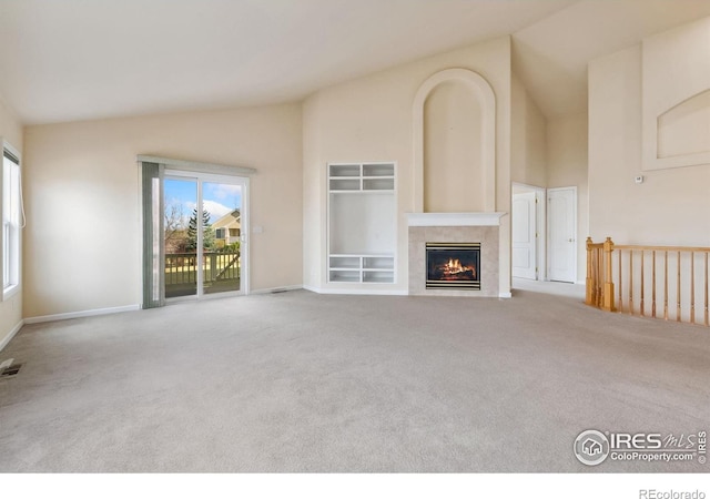 7747 Promontory Dr, Windsor, CO 80528 - unfurnished living room with carpet flooring, a tiled fireplace, high vaulted ceiling, and baseboards