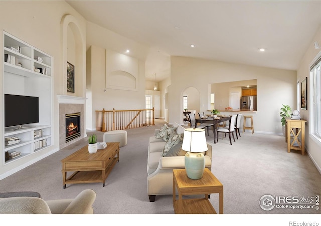 7747 Promontory Dr, Windsor, CO 80528 - living area with built in shelves, healthy amount of natural light, light colored carpet, high vaulted ceiling, and recessed lighting