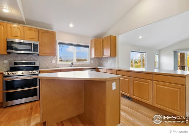 7747 Promontory Dr, Windsor, CO 80528 - kitchen with appliances with stainless steel finishes, lofted ceiling, a sink, light wood finished floors, and light countertops