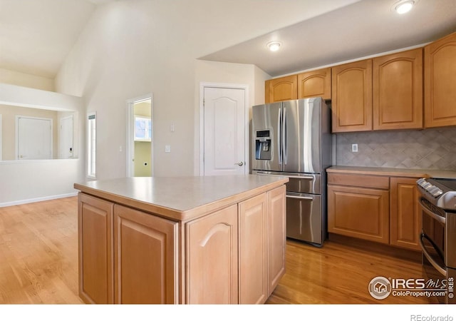 7747 Promontory Dr, Windsor, CO 80528 - kitchen with appliances with stainless steel finishes, a center island, decorative backsplash, light wood-style flooring, and light countertops