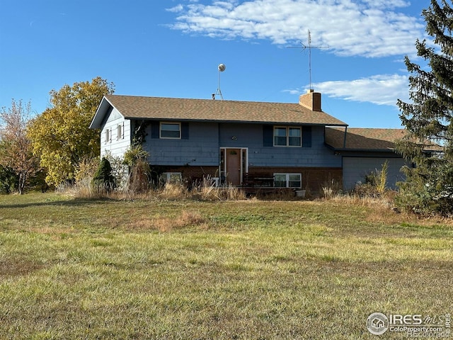 view of front of home with a front lawn, an attached garage, and a chimney