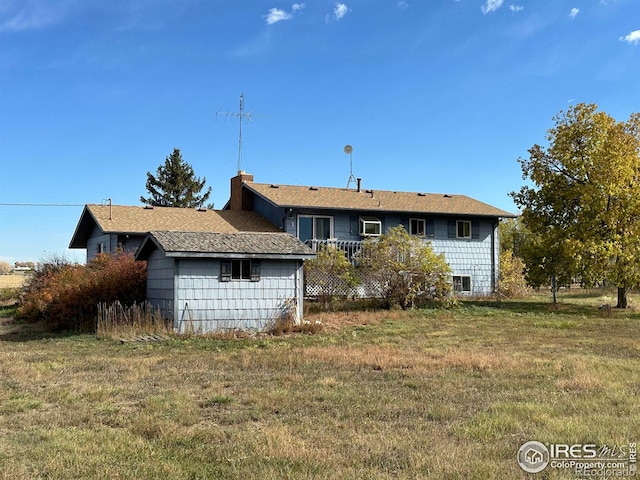rear view of house with a yard and a chimney