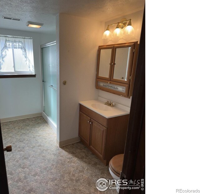 full bathroom with vanity, visible vents, a textured ceiling, and a stall shower