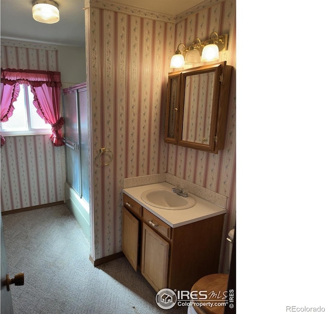 bathroom with vanity, baseboards, wallpapered walls, and toilet