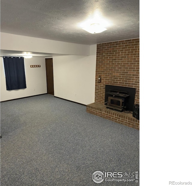 finished basement with a textured ceiling, baseboards, and carpet