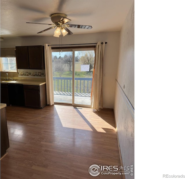 unfurnished dining area featuring wood finished floors, a sink, and ceiling fan