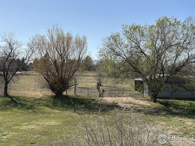 view of yard with a rural view and fence