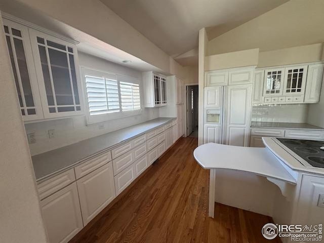 kitchen featuring dark wood-type flooring, white cabinets, and lofted ceiling