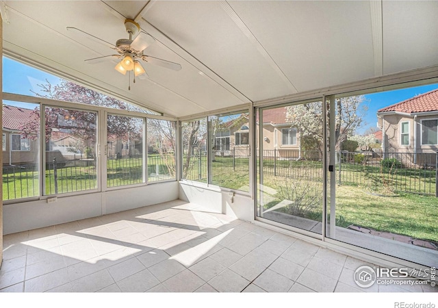 unfurnished sunroom featuring a wealth of natural light and a ceiling fan