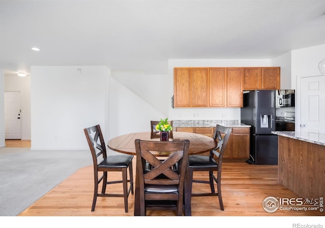 dining area with light wood-type flooring and recessed lighting