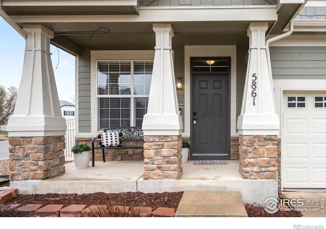 doorway to property with covered porch and a garage