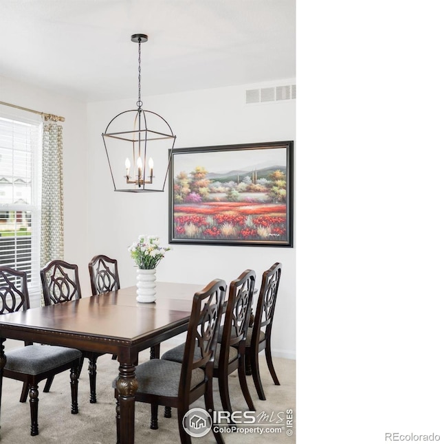 dining area with light carpet, a chandelier, and baseboards