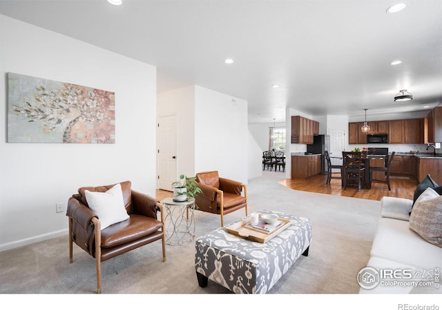 living area featuring recessed lighting, light colored carpet, and baseboards