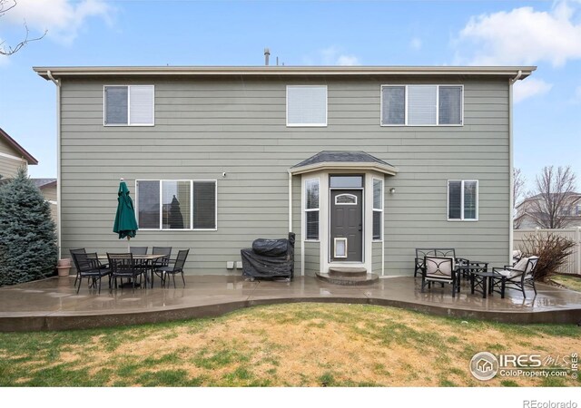 rear view of house featuring a patio and a lawn