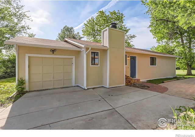 6396 Twin Lakes Rd, Boulder, CO 80301 - view of front of home with driveway, a chimney, and an attached garage