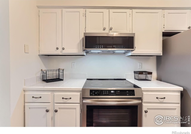 6396 Twin Lakes Rd, Boulder, CO 80301 - kitchen with appliances with stainless steel finishes, white cabinetry, and light countertops