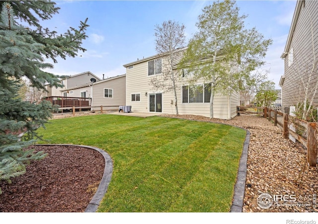 1216 102nd Ave, Greeley, CO 80634 - rear view of house featuring a yard, a patio, a wooden deck, and fence