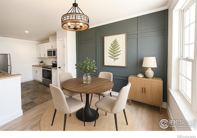 5620 Fossil Creek Pkwy Unit 4106, Fort Collins, CO 80525 - dining space with baseboards, a chandelier, light wood-style floors, and a decorative wall