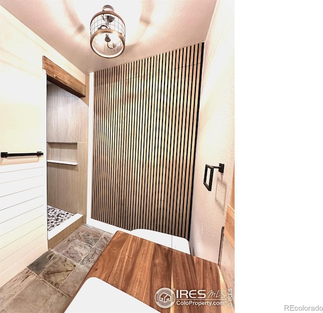 5620 Fossil Creek Pkwy Unit 4106, Fort Collins, CO 80525 - bathroom featuring a tile shower and wooden walls