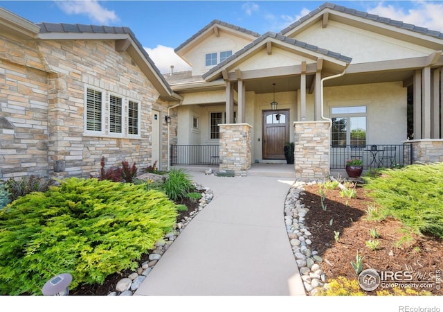 6701 Clovis Ct, Timnath, CO 80547 - entrance to property with stone siding, stucco siding, and covered porch