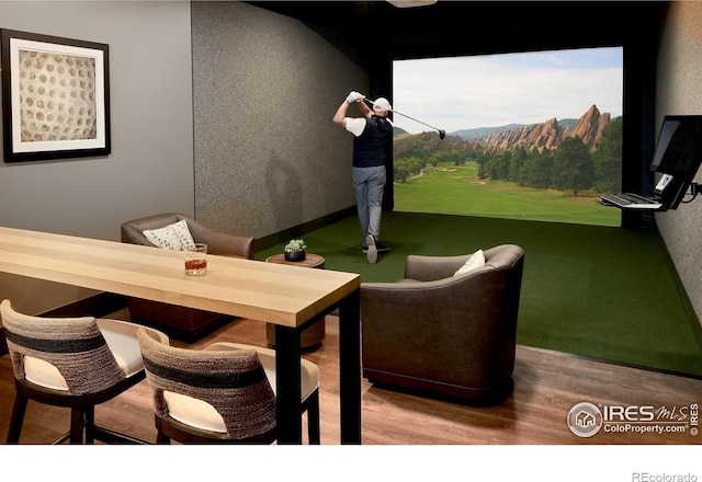 6701 Clovis Ct, Timnath, CO 80547 - dining area with golf simulator, wood finished floors, and a mountain view