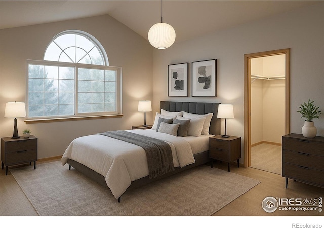 bedroom with multiple windows, light wood-style floors, lofted ceiling, a spacious closet, and baseboards