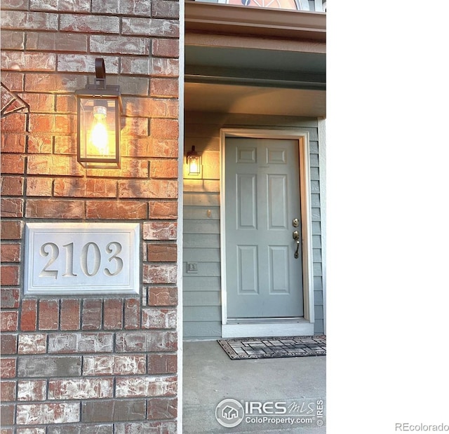 entrance to property featuring brick siding