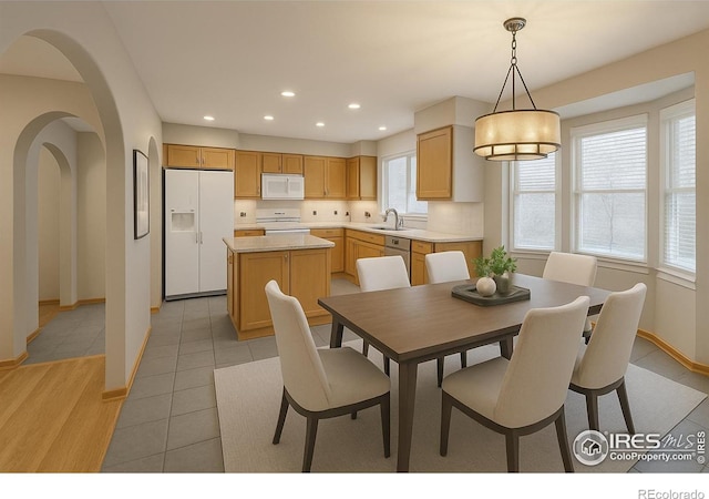 dining space with recessed lighting, baseboards, light tile patterned flooring, and arched walkways