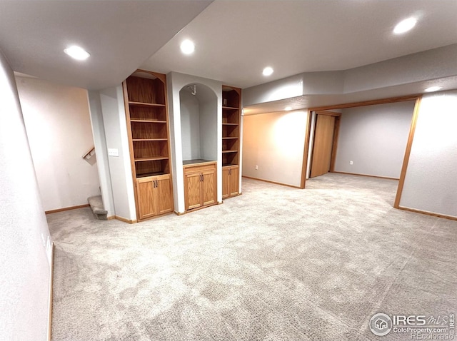 finished basement featuring baseboards, recessed lighting, light carpet, built in features, and stairway
